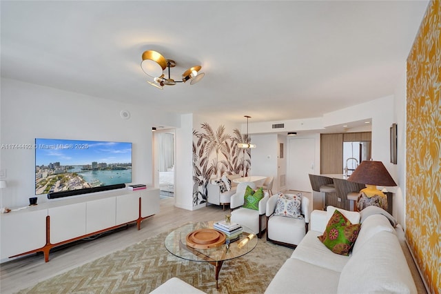 living room featuring an inviting chandelier and light hardwood / wood-style floors