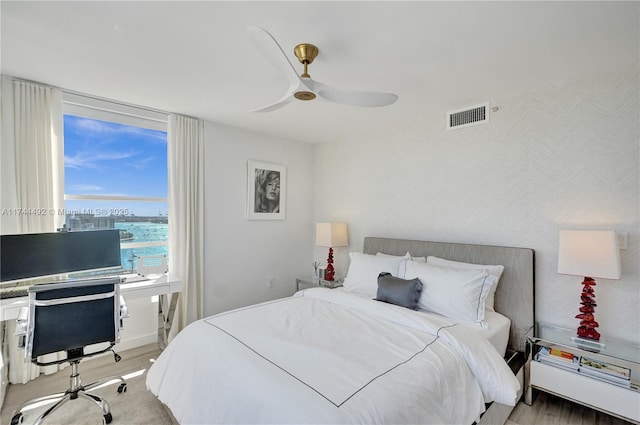 bedroom with ceiling fan and light hardwood / wood-style floors