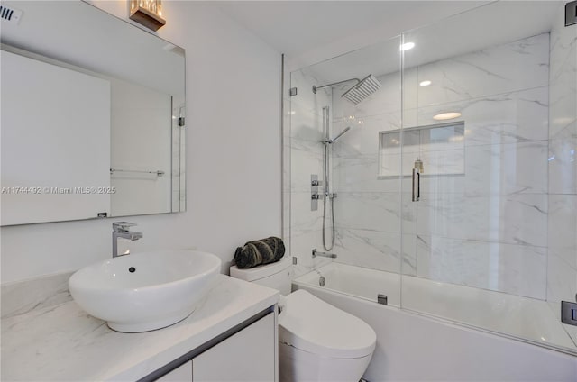 full bathroom featuring vanity, toilet, and combined bath / shower with glass door