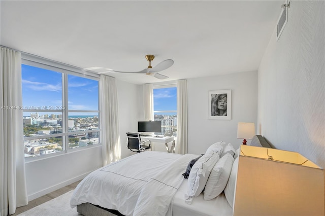 bedroom featuring multiple windows, light wood-type flooring, and ceiling fan