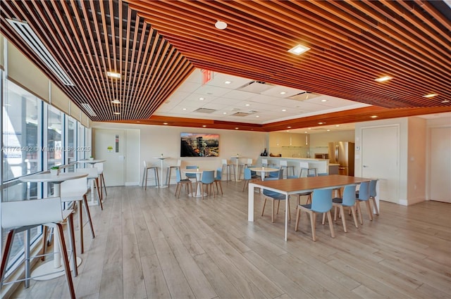 interior space with a tray ceiling and light wood-type flooring