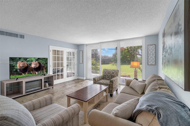 living room with a wall of windows, french doors, and a textured ceiling