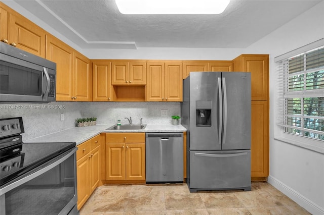 kitchen featuring sink, decorative backsplash, stainless steel appliances, and a textured ceiling