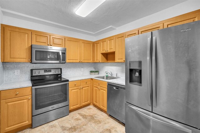 kitchen featuring sink, stainless steel appliances, and a textured ceiling