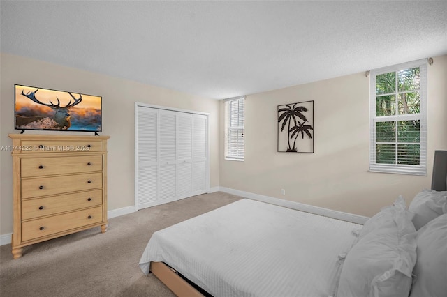 bedroom with carpet flooring, a closet, and a textured ceiling