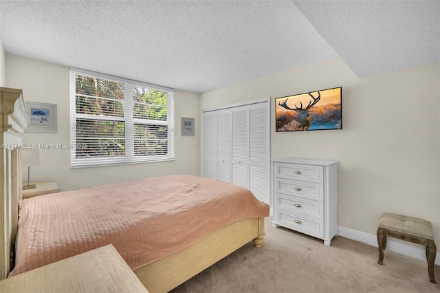 bedroom featuring light carpet, a closet, and a textured ceiling