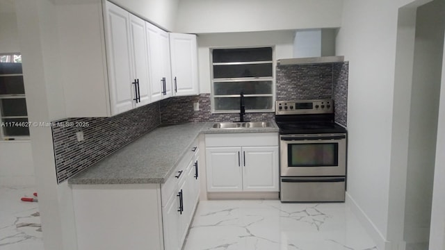 kitchen with a sink, marble finish floor, decorative backsplash, stainless steel electric range oven, and wall chimney exhaust hood