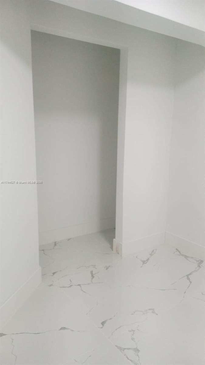 basement with marble finish floor and baseboards