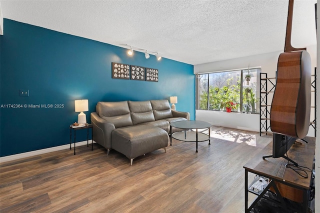 living room with hardwood / wood-style flooring, track lighting, and a textured ceiling