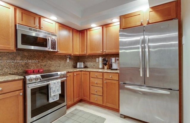 kitchen with backsplash, stainless steel appliances, and light stone countertops