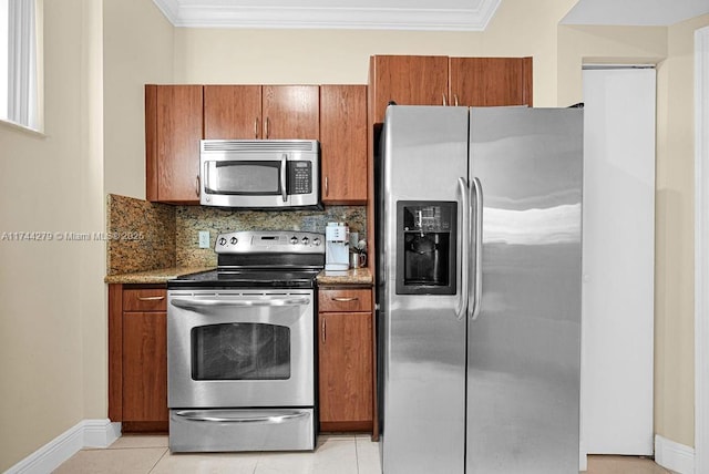 kitchen with light tile patterned floors, crown molding, dark stone countertops, stainless steel appliances, and decorative backsplash