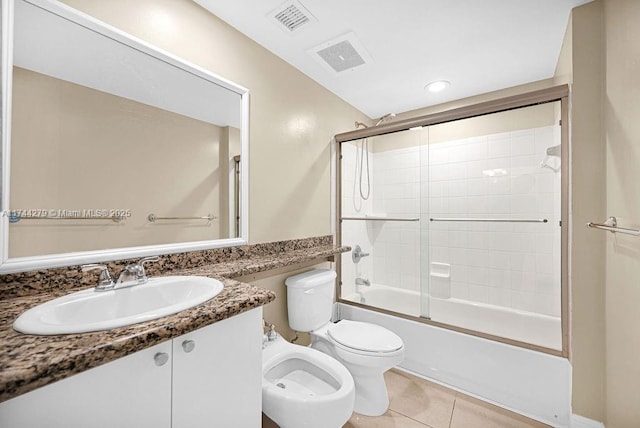 full bathroom featuring toilet, bath / shower combo with glass door, a bidet, vanity, and tile patterned flooring