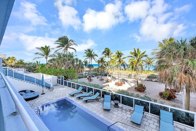 view of pool with a patio area and a water view