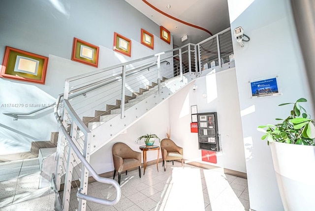 stairs featuring tile patterned flooring and a towering ceiling