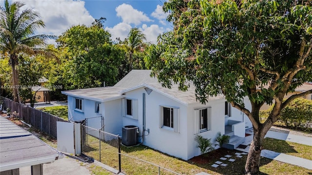 view of property exterior with a lawn and central air condition unit