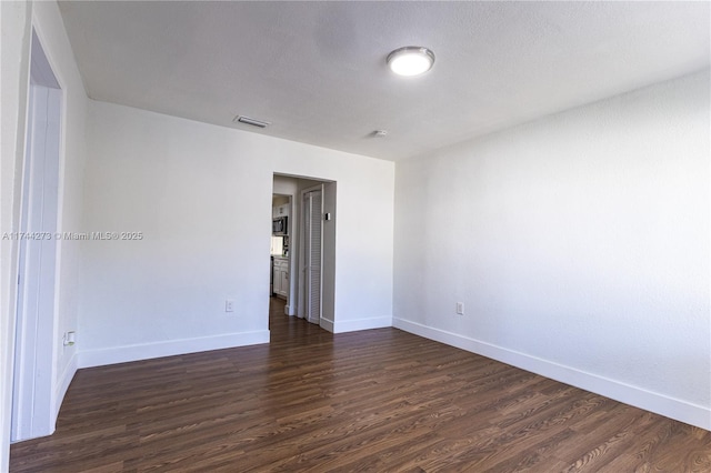 unfurnished room featuring dark hardwood / wood-style floors and a textured ceiling