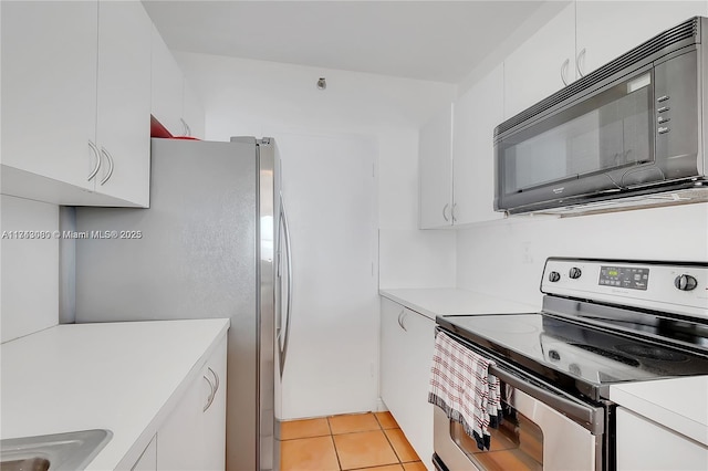 kitchen featuring light tile patterned flooring, appliances with stainless steel finishes, sink, and white cabinets