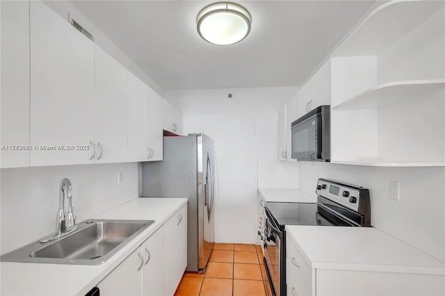 kitchen featuring white cabinetry, sink, light tile patterned floors, and stainless steel appliances