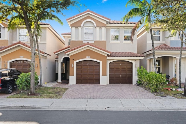 view of front facade featuring stucco siding, an attached garage, and driveway