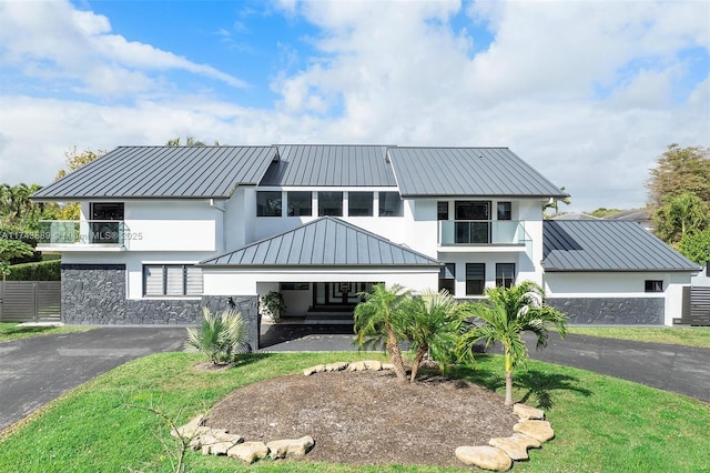 view of front facade with a front yard and a balcony