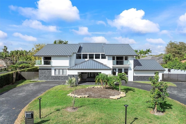 modern farmhouse style home featuring a balcony and a front lawn