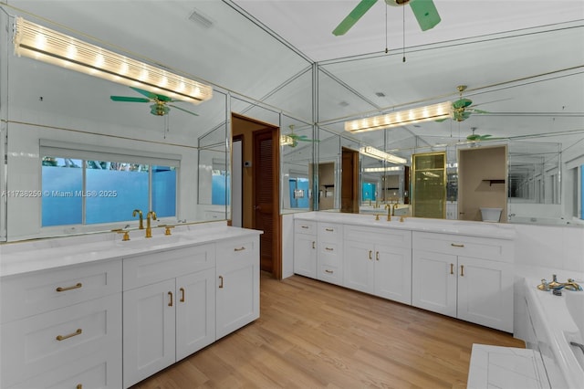 bathroom with vanity, wood-type flooring, a bathing tub, and ceiling fan