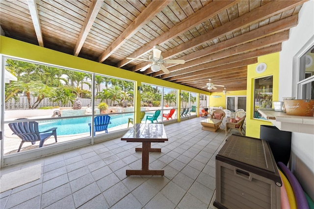 sunroom / solarium with a fenced in pool, ceiling fan, and a patio area