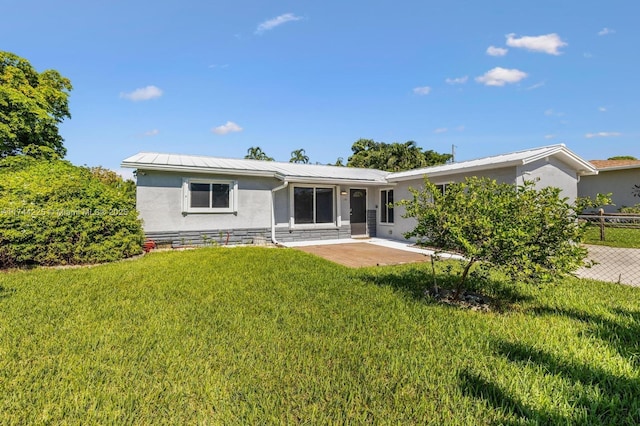 back of property with metal roof, a patio, stone siding, a lawn, and stucco siding