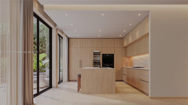 kitchen with tasteful backsplash, a kitchen island, light brown cabinets, and double oven