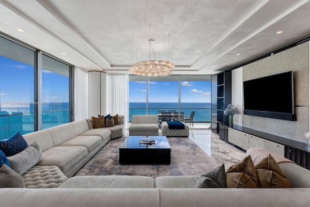 living room with an inviting chandelier, floor to ceiling windows, and a raised ceiling