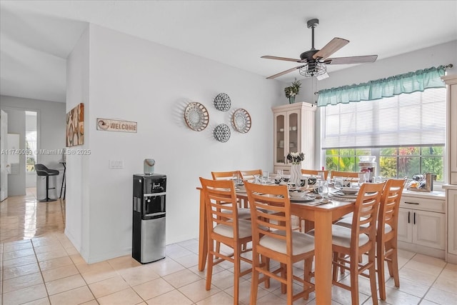 dining space featuring light tile patterned floors, ceiling fan, and baseboards