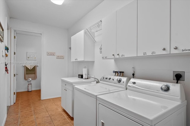 washroom with washing machine and dryer, cabinet space, baseboards, and light tile patterned floors