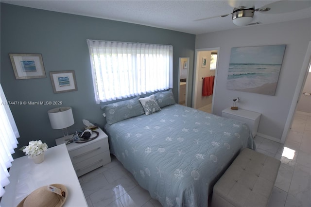 bedroom with ceiling fan and a textured ceiling