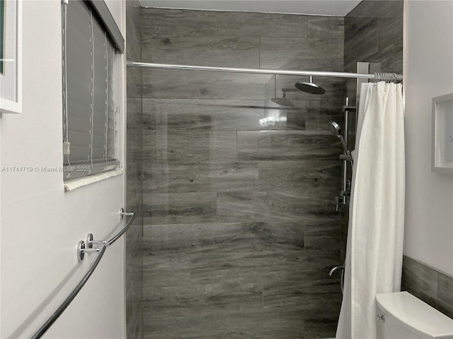 bathroom featuring a shower with curtain and toilet