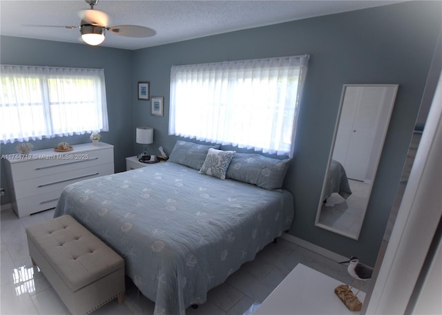 bedroom featuring ceiling fan and a textured ceiling