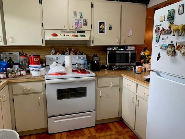 kitchen featuring white cabinetry, white appliances, and exhaust hood