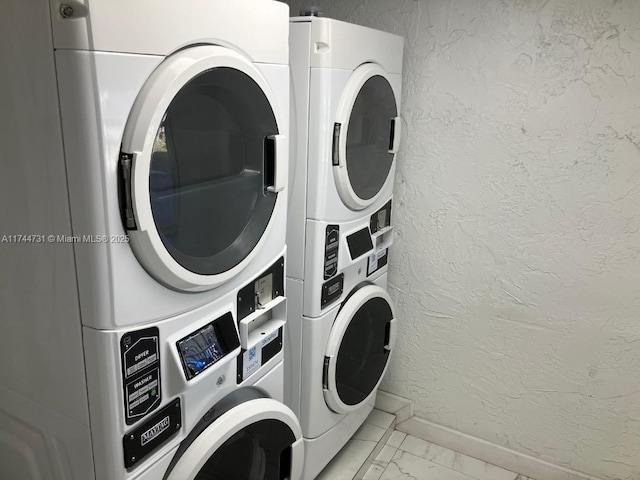 clothes washing area with stacked washer / dryer