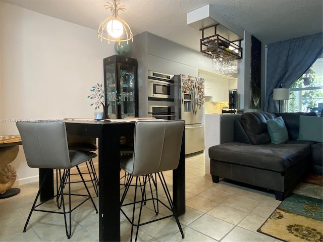 tiled dining space with a textured ceiling