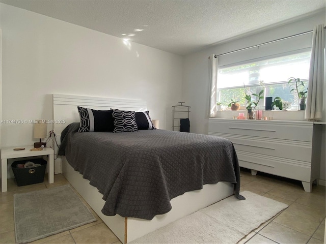 bedroom with light tile patterned floors and a textured ceiling