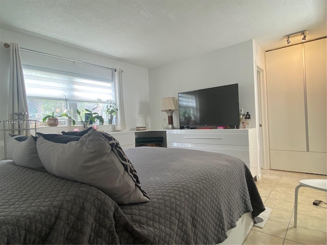 bedroom with a textured ceiling and light tile patterned floors