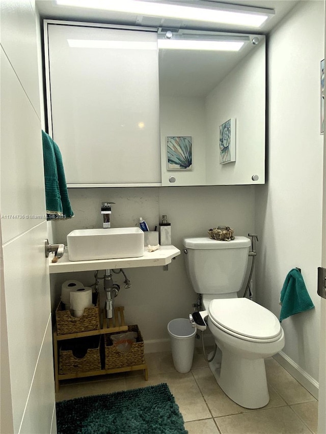 bathroom with tile patterned flooring, sink, and toilet