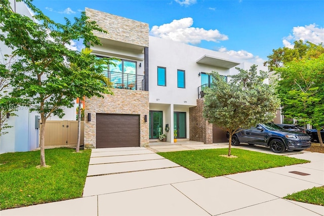 contemporary home featuring a balcony, a garage, and a front lawn