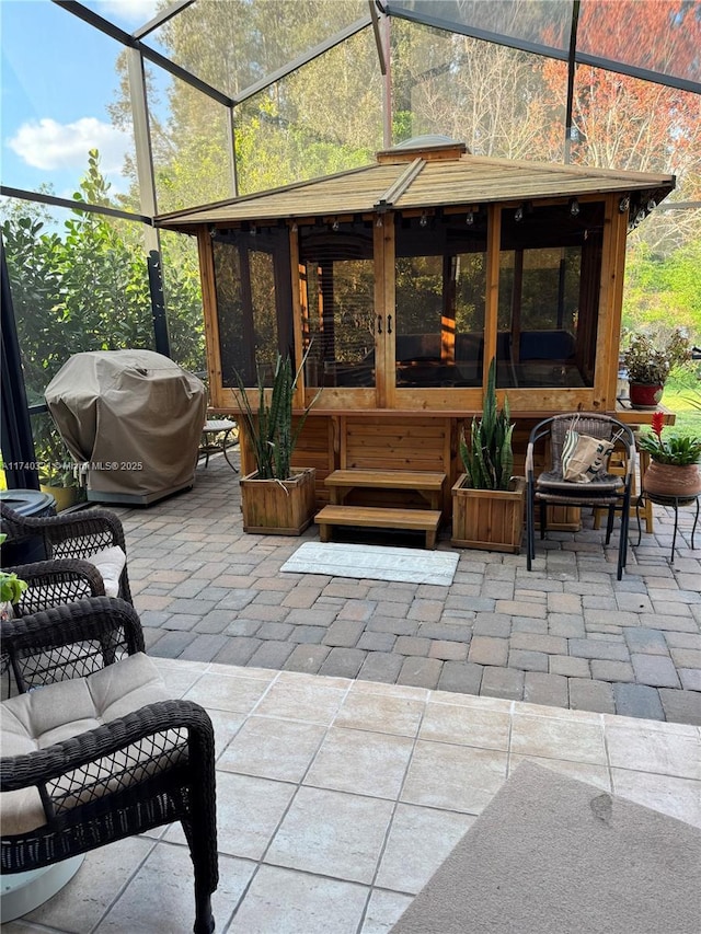 view of patio with a grill, a lanai, an outdoor living space, and a sunroom