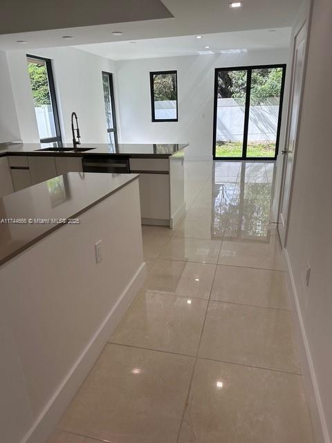 kitchen featuring a healthy amount of sunlight, sink, and white cabinets