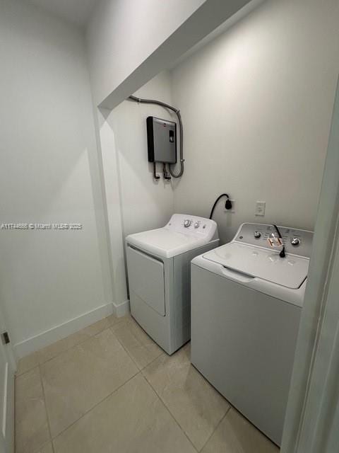 clothes washing area with water heater, light tile patterned flooring, and separate washer and dryer