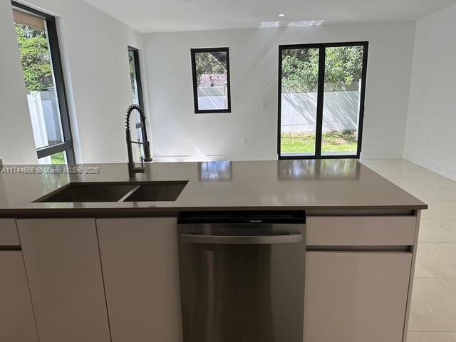 kitchen with light tile patterned flooring, sink, and stainless steel dishwasher