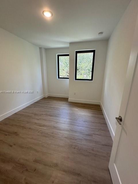 spare room with dark hardwood / wood-style flooring