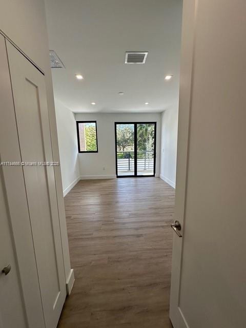 hallway with hardwood / wood-style flooring