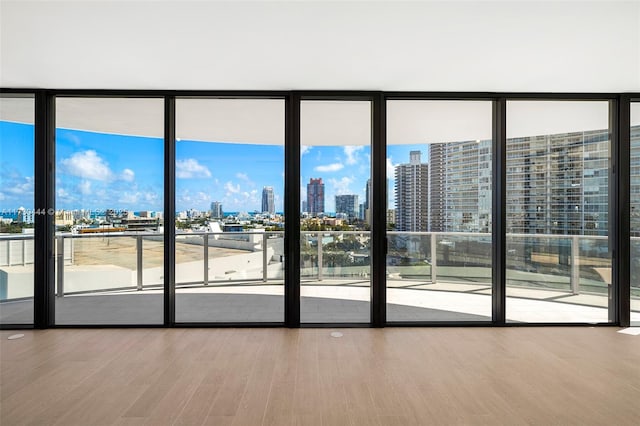 doorway to outside featuring hardwood / wood-style flooring and a wall of windows