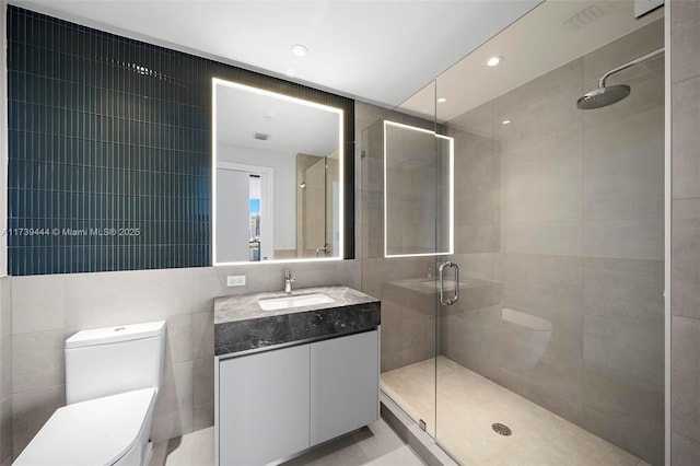 bathroom with vanity, tile walls, an enclosed shower, and toilet